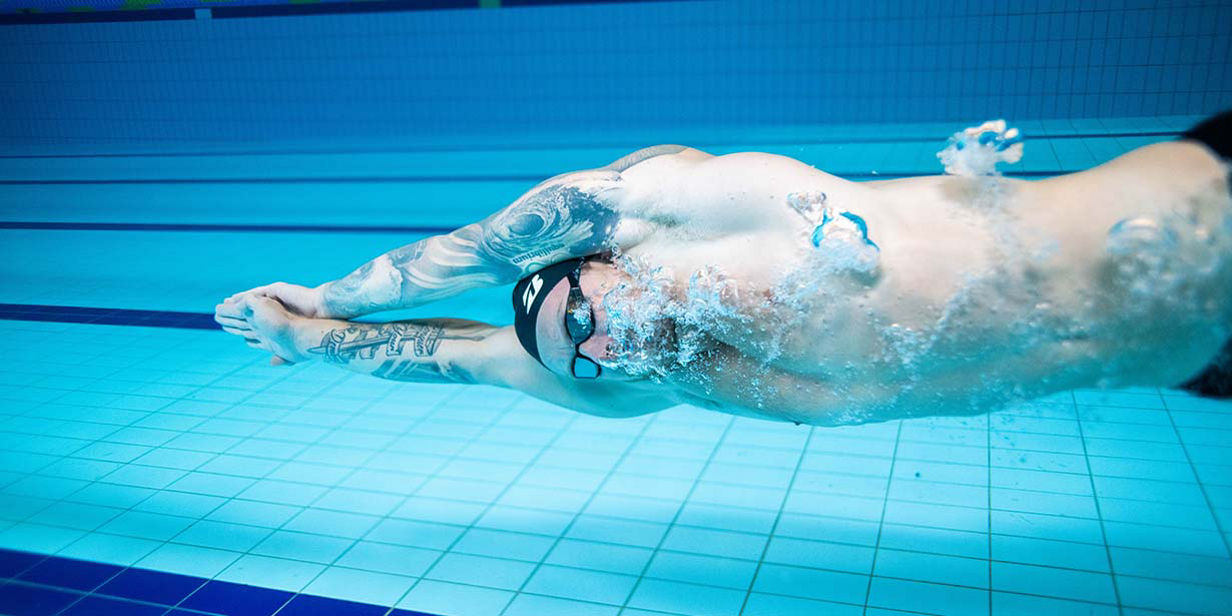 Under water image of Adam Peaty swimming.